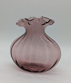 a pink glass vase sitting on top of a table