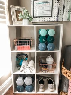 a white bookcase filled with different types of dumbs and kettles on top of it