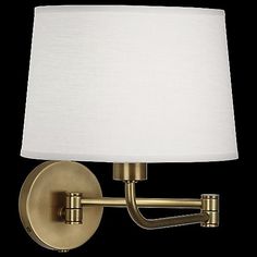 a wall light with a white shade on the side and a black background behind it