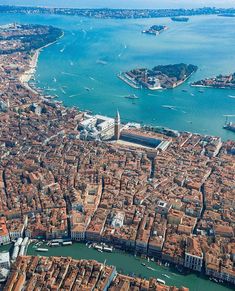 an aerial view of venice, italy with the city in the foreground and water surrounding it