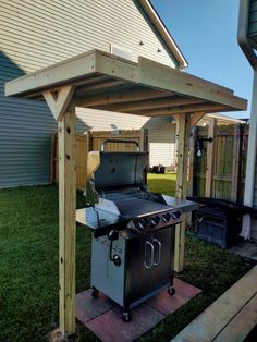 an outdoor bbq grill in the middle of a yard