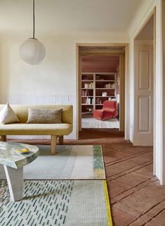 a living room with a couch, coffee table and bookshelf in the background