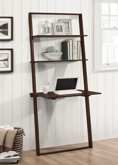 a laptop computer sitting on top of a wooden shelf next to a wall mounted bookshelf