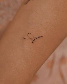 a woman's arm with a small tattoo on it