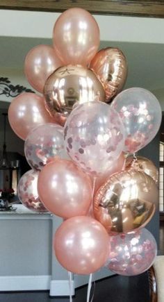 a bunch of pink and gold balloons in the shape of a heart on a stick