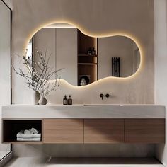 a bathroom with a large mirror above the sink and lights on the wall behind it