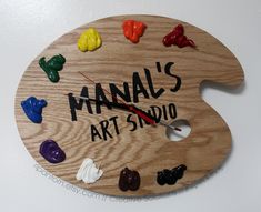 a wooden clock with many different colored gummy bears on it's face and the words manuals art studio