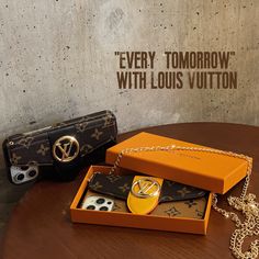 an orange box with two pieces of louis vuitton in it on a table