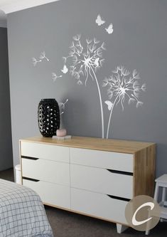 a bed room with a dresser and a large wall decal on the side of it