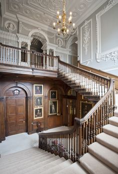 an ornate staircase with paintings and chandelier