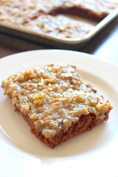 a piece of cake sitting on top of a white plate next to a baking pan