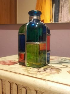 a colorful glass bottle sitting on top of a table