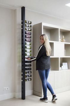 a woman standing next to a wine rack