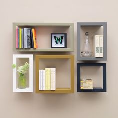 three shelves with books and vases on each shelf, one has a butterfly in the middle