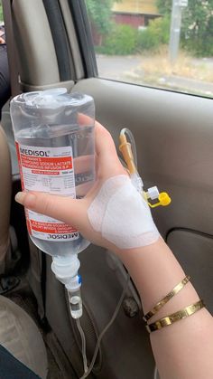 a person in a car with bandages on their arm and an iv device attached to the arm