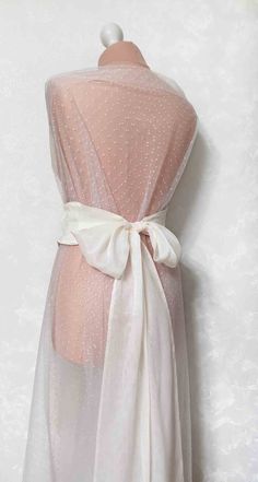 the back of a dress with white polka dots on it and a bow at the waist