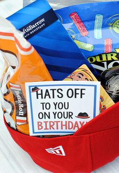 a red basket filled with lots of food and candy on top of a white table