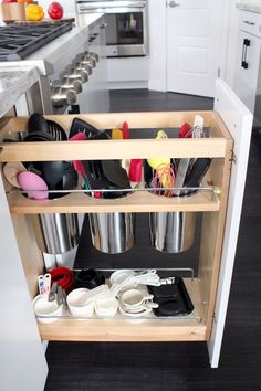 an open cabinet in a kitchen filled with utensils