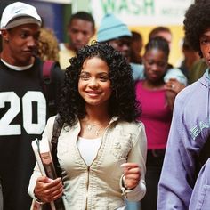 a group of young people standing next to each other in front of a crowd on the street