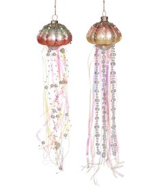 two jellyfish ornaments hanging from strings with pearls and beads on them, one is pink and the other is gold