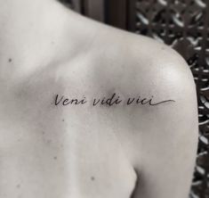 the back of a man's shoulder with an inscription written in cursive ink