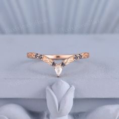 a diamond ring sitting on top of a white cloth covered box with the word love written in it