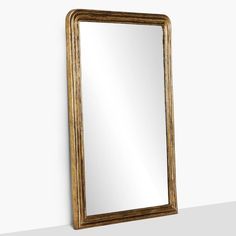 a gold framed mirror hanging on the wall