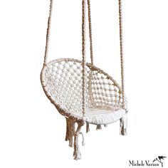 a white hanging chair with rope and tassels