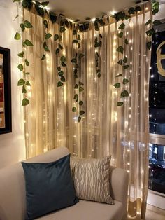 a living room filled with furniture and lots of greenery hanging from the ceiling above