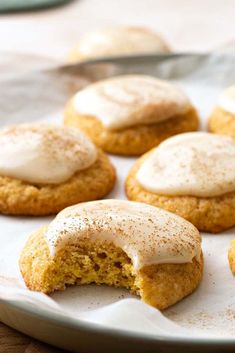 several cookies with frosting on top sitting on a plate