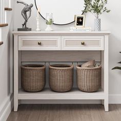 a white table with baskets under a mirror