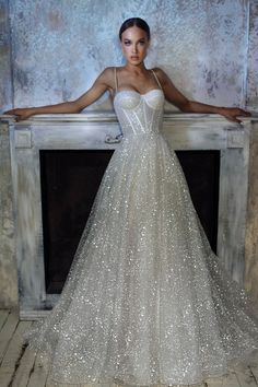 a woman standing in front of a fire place wearing a dress with sequins