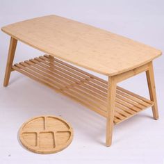 a wooden table with two shelves and a round object on the floor next to it