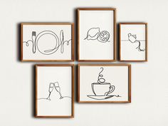 four framed drawings on the wall above a coffee cup