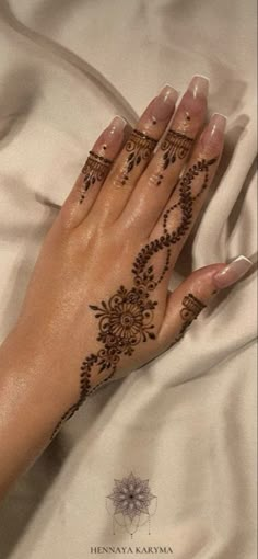 a woman's hand with hendix on it laying on a white sheet