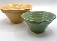 two bowls sitting side by side on a white surface