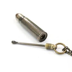 a metal object with a keychain and chain attached to it on a white surface