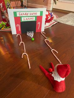 candy canes are on the floor next to an elf's hat