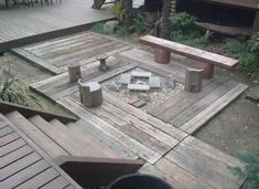 an outdoor fire pit surrounded by wooden benches