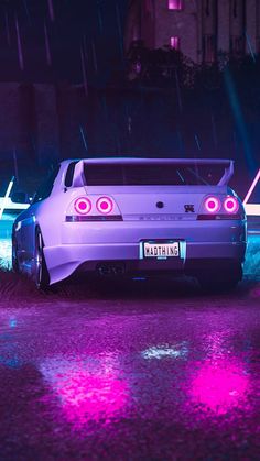 a purple car parked in the rain at night