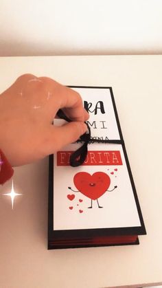 a hand holding a mouse over a card with hearts on it and the word i love you in spanish