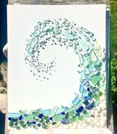 a painting made out of sea glass sitting on top of a table