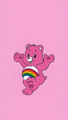 a pink teddy bear flying through the air with a rainbow ball in it's mouth