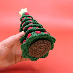 a crocheted christmas tree ornament being held by someone's hand