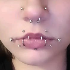 a woman with piercings on her face and nose