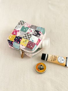 a small patchwork purse next to a tube of toothpaste and lip balm