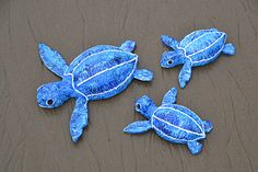 three blue sea turtles laying on the sand