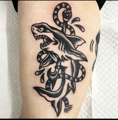 a black and white photo of a tattoo with a lizard on it's leg