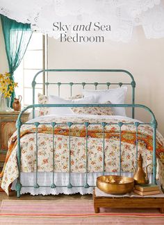 a bed room with a neatly made bed and flowers on the wall next to it