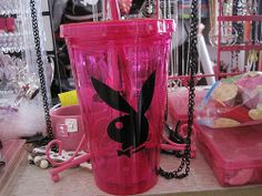 a pink plastic cup with a black bunny on it and chains hanging from the side